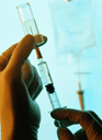 Photo of a gloved hand holding a syringe